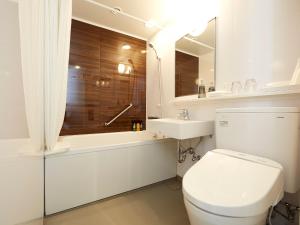 uma casa de banho branca com um WC e um lavatório em Hearton Hotel Shinsaibashi Nagahoridouri em Osaka
