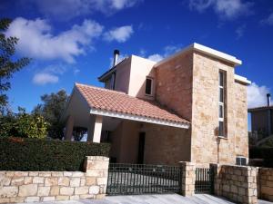 a brick house with a fence in front of it at Amorosa Villas in Polis Chrysochous