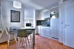 a kitchen with a table and chairs in a room at Penthouse vue mer avec Rooftop,Jacuzzi,et parking privé in Antibes