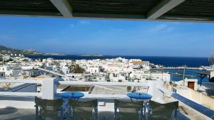 a balcony with chairs and a view of the city at Lefteris in Mikonos