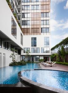 una piscina di fronte a un edificio di GAIA Cosmo Hotel a Yogyakarta