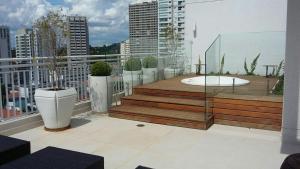 a balcony with a hot tub on top of a building at Now Alto Da Boa Vista in São Paulo