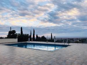 a swimming pool in a patio with the ocean in the background at TROUZINI VILLA 2 in Peyia