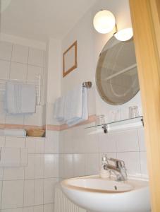 a bathroom with a sink and a mirror and towels at Hotel Goldenes Faß in Würzburg