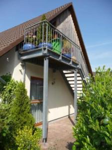 a house with a balcony with people sitting on it at 4_Zimmer_Ferienwohnung in Wathlingen