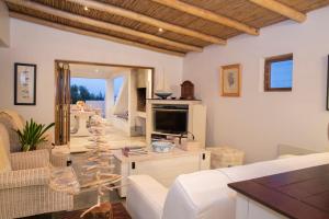 a living room with a white couch and a tv at Sugar Shack in Paternoster