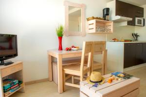 a small kitchen with a small table and a dining room at Résidence Goélia Les Jardins de l'Oyat in Mimizan-Plage