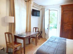 a bedroom with a table and a bed and a bed and a room at Les Bastidieres - Cap Brun in Toulon