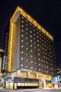 東京的住宿－銀座名鐵繆思飯店，一座在晚上有灯的大建筑