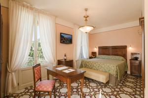ガルニャーノにあるHotel Gardenia al Lagoのベッドルーム1室(ベッド1台、デスク、テーブル付)