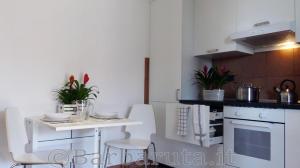 a white kitchen with a white table and chairs at Barbaruta RTA in Grosseto +14 photos