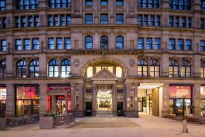 a large building with stores in front of it at Roomzzz Manchester Victoria in Manchester