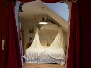 Schlafzimmer mit Himmelbett und roten Vorhängen in der Unterkunft Ferienwohnung Comic Fantasy in Lindau