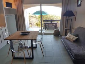 a living room with a table and a couch at Résidence Costa d'Oru in Saint-Florent