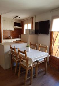een keuken met een tafel en stoelen en een keuken met een aanrecht bij Cal Sastre in Castellar de NʼHug