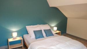 a bedroom with a white bed with two lamps on tables at La bressaude - vacances-en-vosges - ménage compris in La Bresse