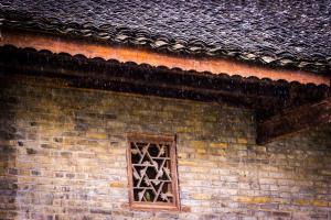 uma janela do lado de um edifício de tijolos em Rural House em Yangshuo