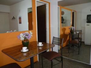 ein Tisch und Stühle mit einer Blumenvase drauf in der Unterkunft Nuestro refugio en Mendoza in Mendoza
