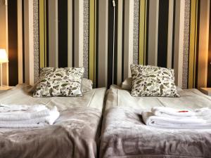 a bed with two pillows and towels on it at Järnvägshotellet in Gävle