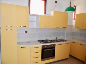 リド・ディ・イエゾロにあるCondominio Romeoのキッチン(黄色のキャビネット、シンク付)