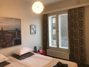 a bedroom with a bed and a window and a chandelier at City Apartments in Jyväskylä