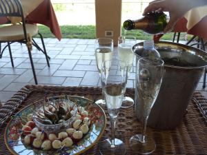 Genius Loci Country Inn في بيفانيا: طاولة مع كؤوس من النبيذ وصحن من الطعام