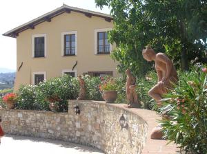 a statue of people standing on a wall in front of a house at Genius Loci Country Inn in Bevagna