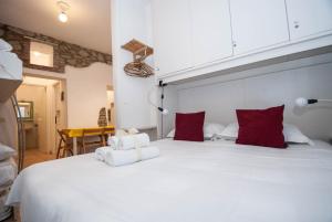 een slaapkamer met een groot wit bed met rode kussens bij Casa Di Mezzo by Arbaspàa in Manarola