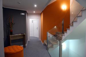 a hallway with orange walls and a stair case at Hotel Altiana in Ourense