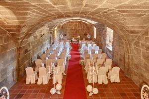 una habitación con una fila de mesas y sillas en un túnel en Eurostars Monumento Monasterio de San Clodio Hotel, en Leiro 37 fotos más