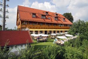 a large building with people sitting at tables in front of it at Landhotel Hoisl-Bräu in Penzberg