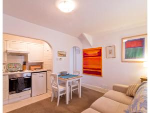 una cucina e un soggiorno con un tavolo e un divano di Sand Dune a Looe