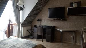 カジミエシュ・ドルニにあるApartament 30 Angel - Pod Aniołemのテレビ、デスク、椅子が備わる客室です。