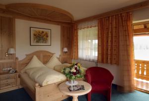 a bedroom with a couch and a table with a vase of flowers at Landhotel Hoisl-Bräu in Penzberg +29 photos