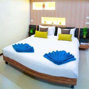 a large bed with two blue pillows on it at Walking Street Residence - Boutique Suites near the Beach & Walking Street in Pattaya South