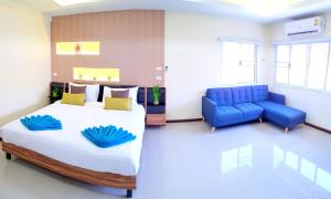 a bedroom with a large bed and a blue couch at AceStar Premier - Boutique Suites near the Beach & Walking Street in Pattaya South
