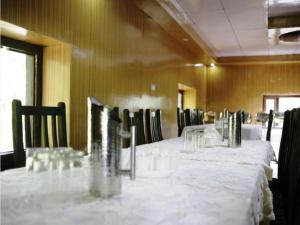 een kamer met tafels en stoelen met witte tafellakens bij Nubra Leisure Camp in Leh