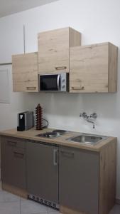 a kitchen with a sink and a microwave at Gästehaus Klug in Sankt Stefan ob Stainz