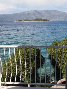 uma varanda com vista para a água e uma ilha em Apartments Lumbarda Beach em Lumbarda