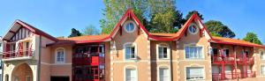 um grande edifício com um telhado vermelho em Lagrange Vacances - Résidence Jardin Mauresque em Arcachon