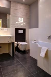 ein Badezimmer mit einer Badewanne, einem WC und einem Waschbecken in der Unterkunft The Heidelberg Exzellenz Hotel in Heidelberg