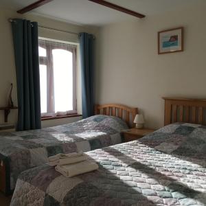 1 Schlafzimmer mit 2 Betten und einem Fenster in der Unterkunft Lower Thornton Farm in Exeter