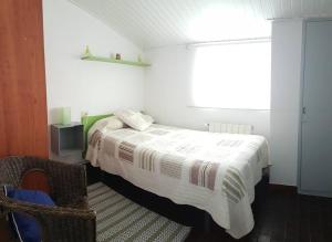 1 dormitorio con 1 cama, 1 silla y 1 ventana en Apartamento en vivienda unifamiliar, con plaza de garaje en Santiago de Compostela