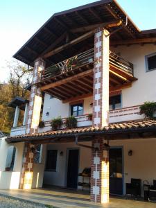 een huis met een balkon er bovenop bij Agriturismo Bio-Ecologico Sant'Isidoro in Roccaforte Mondovì
