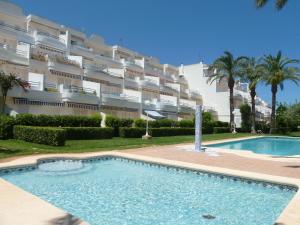 una piscina frente a un gran edificio de apartamentos en Las Barcas LOCDENIA, en Denia