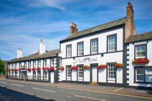 a row of buildings on a street with flowers at Trout Hotel in Cockermouth