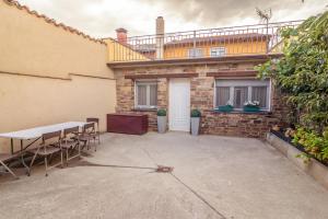 a patio with a table and chairs in front of a building at Casa La Abuela in Ferreras de Arriba