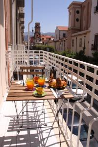 een tafel met eten en drinken op een balkon bij Francesco Suite in Sorrento