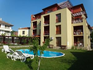 a house with a swimming pool and two lawn chairs at Condo Hotel Valentina in Obzor