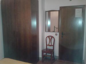 a room with a door and a chair and a mirror at El Hogar de Ardwina in Alía